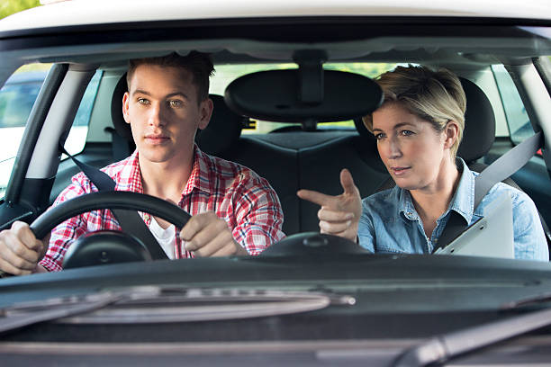 A man driving and a woman instructing him