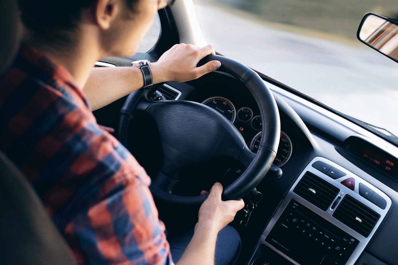 A man driving, focus on the steering wheel