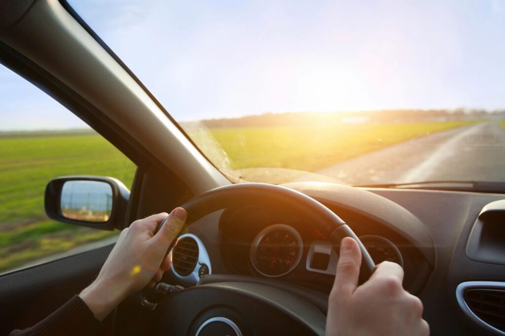 person driving down highway sunshine