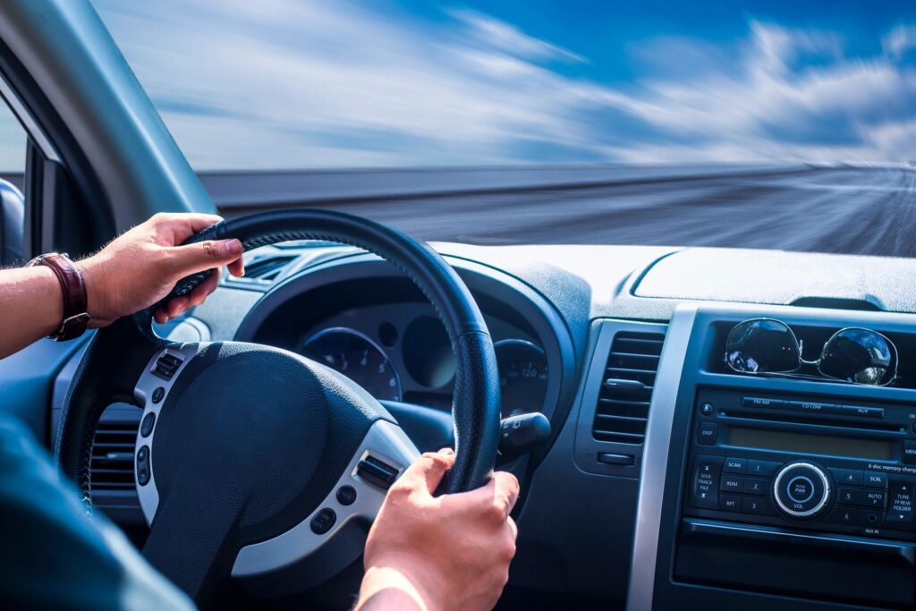 person driving down highway blue sky