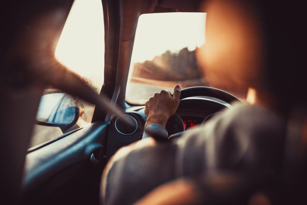 view of steering wheel and driver from back seat