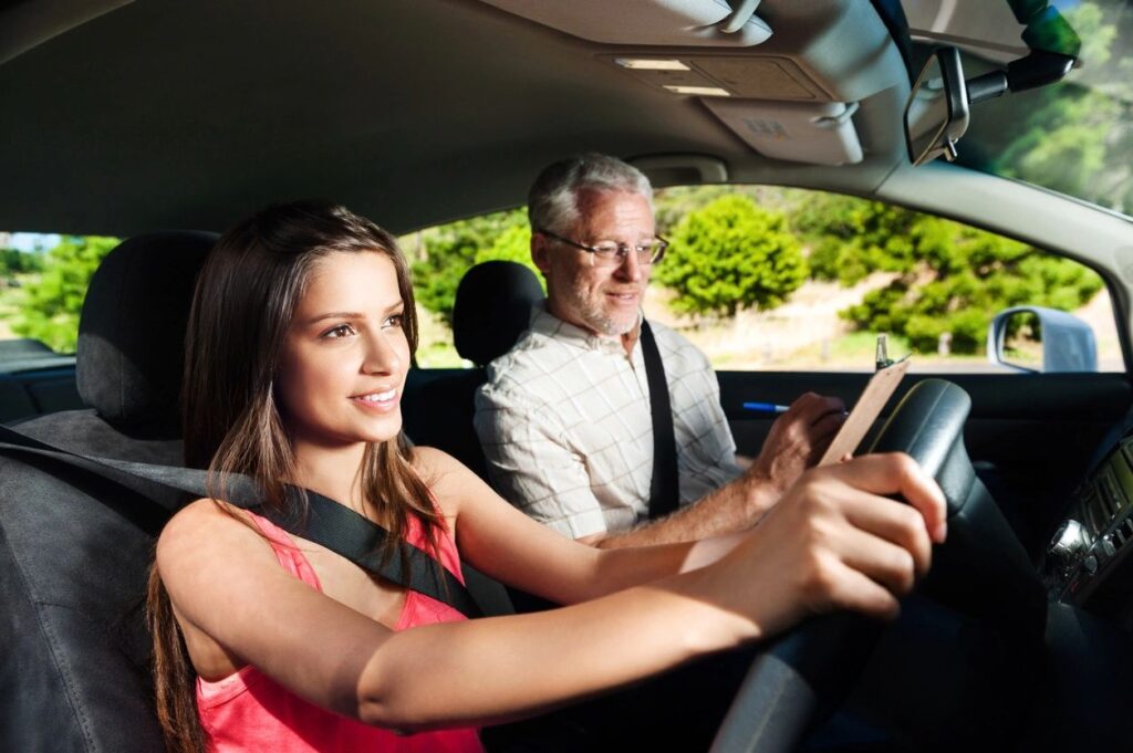 female student driver with driving coach