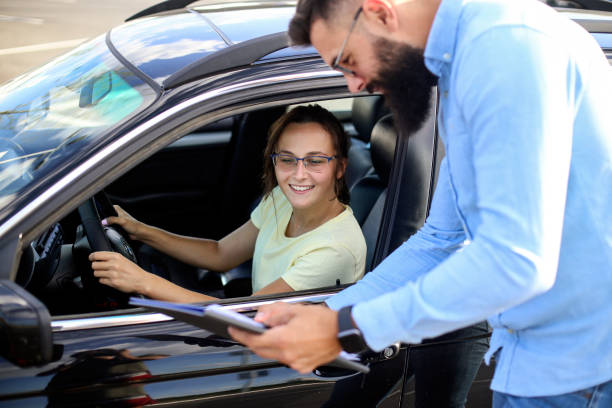 An instructor showing a paper to a student driver