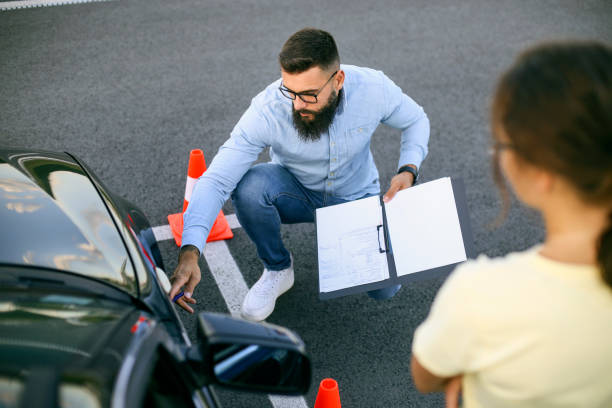 An instructor pointing at the car’s tire