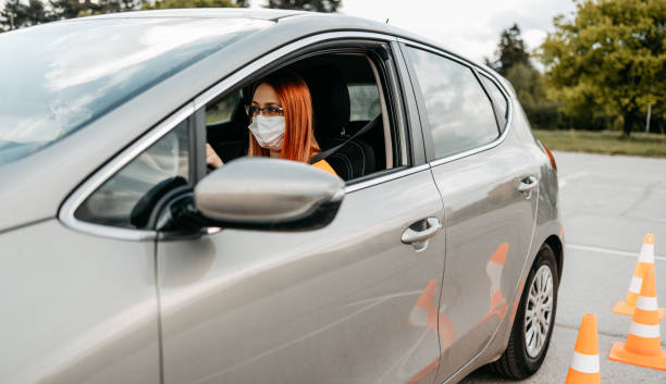 A woman driving while wearing a mask