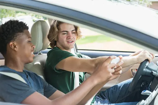man looking at friend’s phone in car