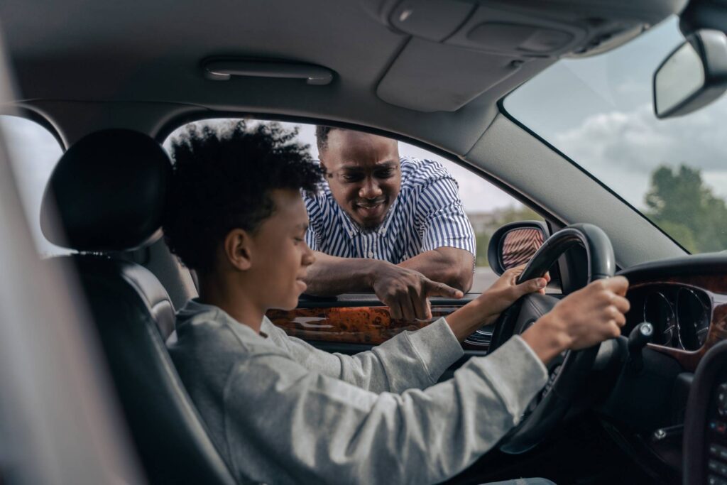 An instructor teaching about the steering wheel from outside the car